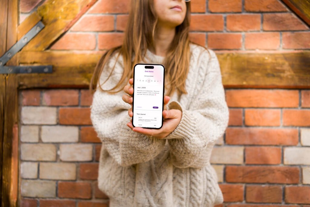mockuuups woman in sweater holding an iphone 14 pro mockup